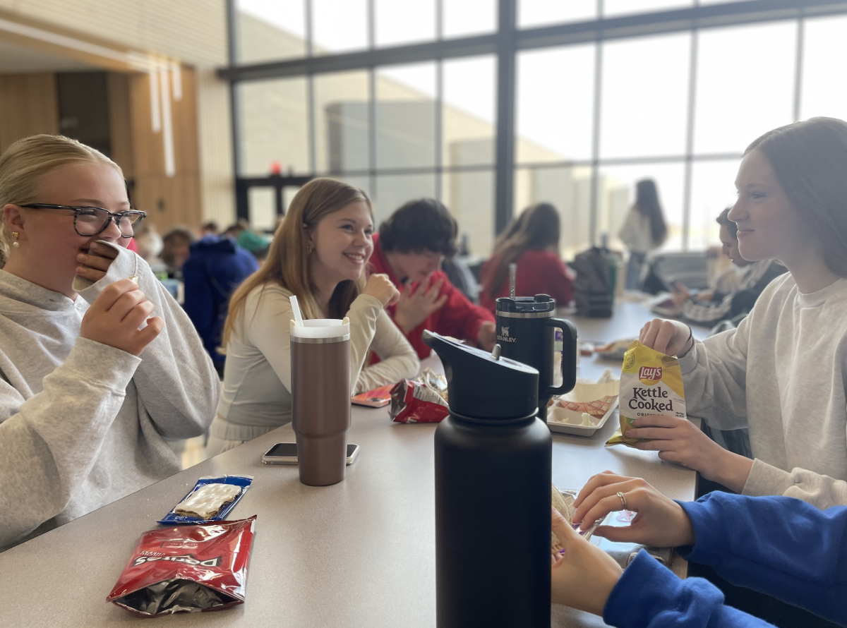 Chatting with friends, sophomores Addilyn Nikodym, Laci Smith, Seth Milne, Madisyn Wisnieski and Madilon Sedillo-Dougall (unpictured) enjoy their respective lunches together. The group ate together on Feb. 27 during first lunch.